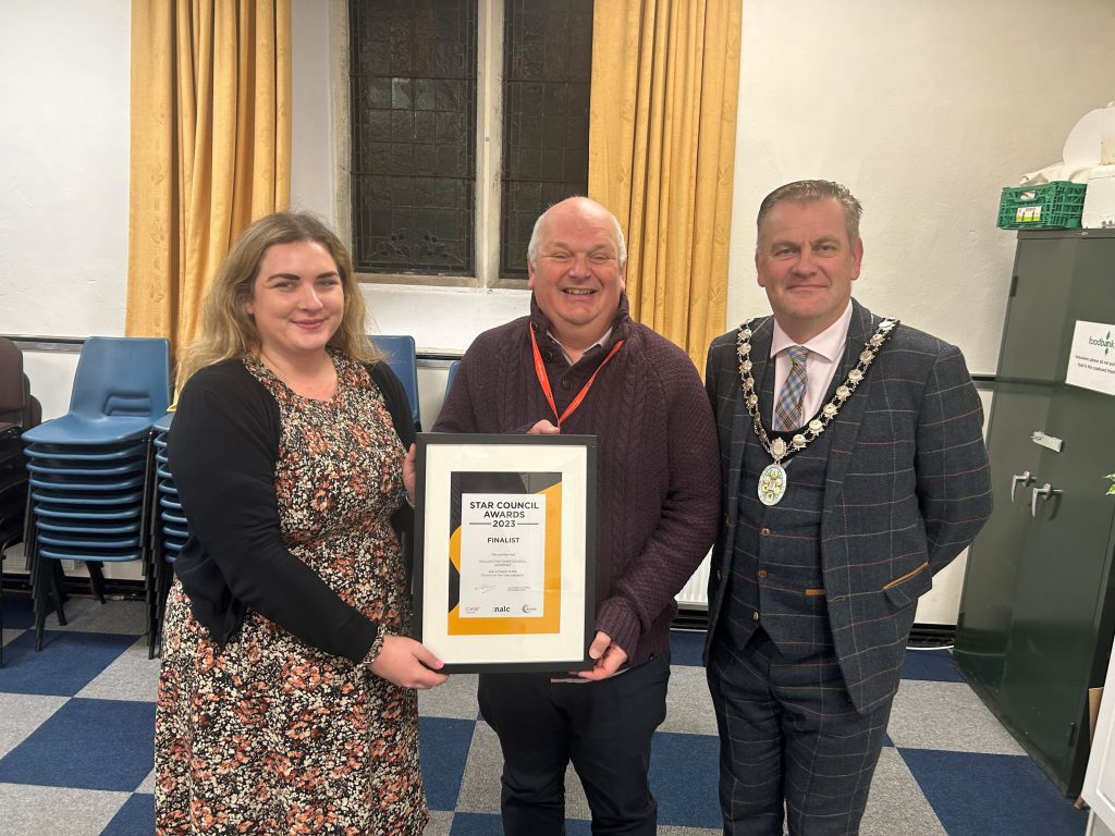 Deputy Mayor Catherine Govier, Town Clerk Dave Farrow, and Mayor Marcus Barr hold up a certificate recognising Wellington Town Council as Council of the Year Finalists