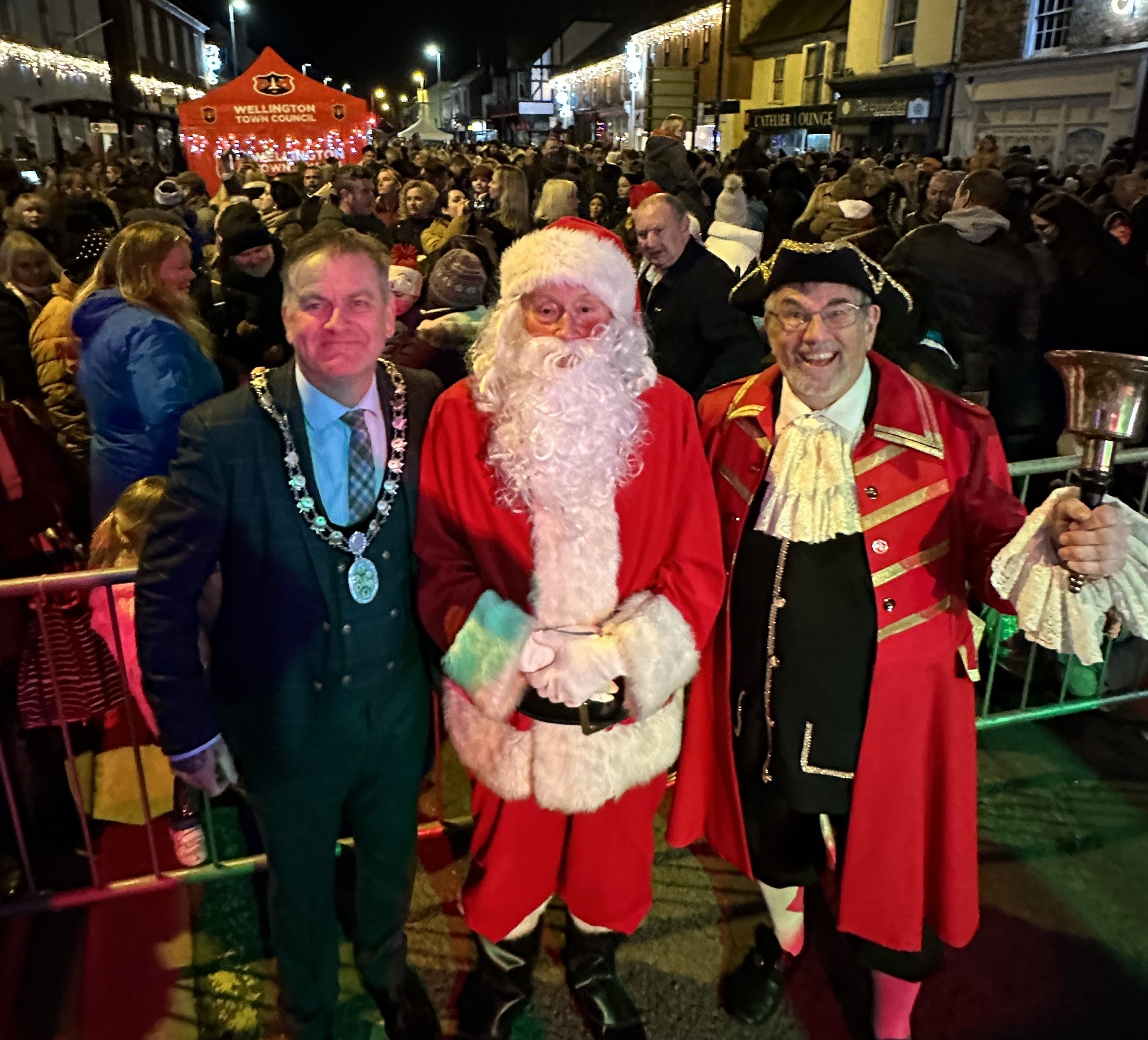 Mayor Marcus Barr, Santa Claus, and the Town Crier stand in front of a large crowd