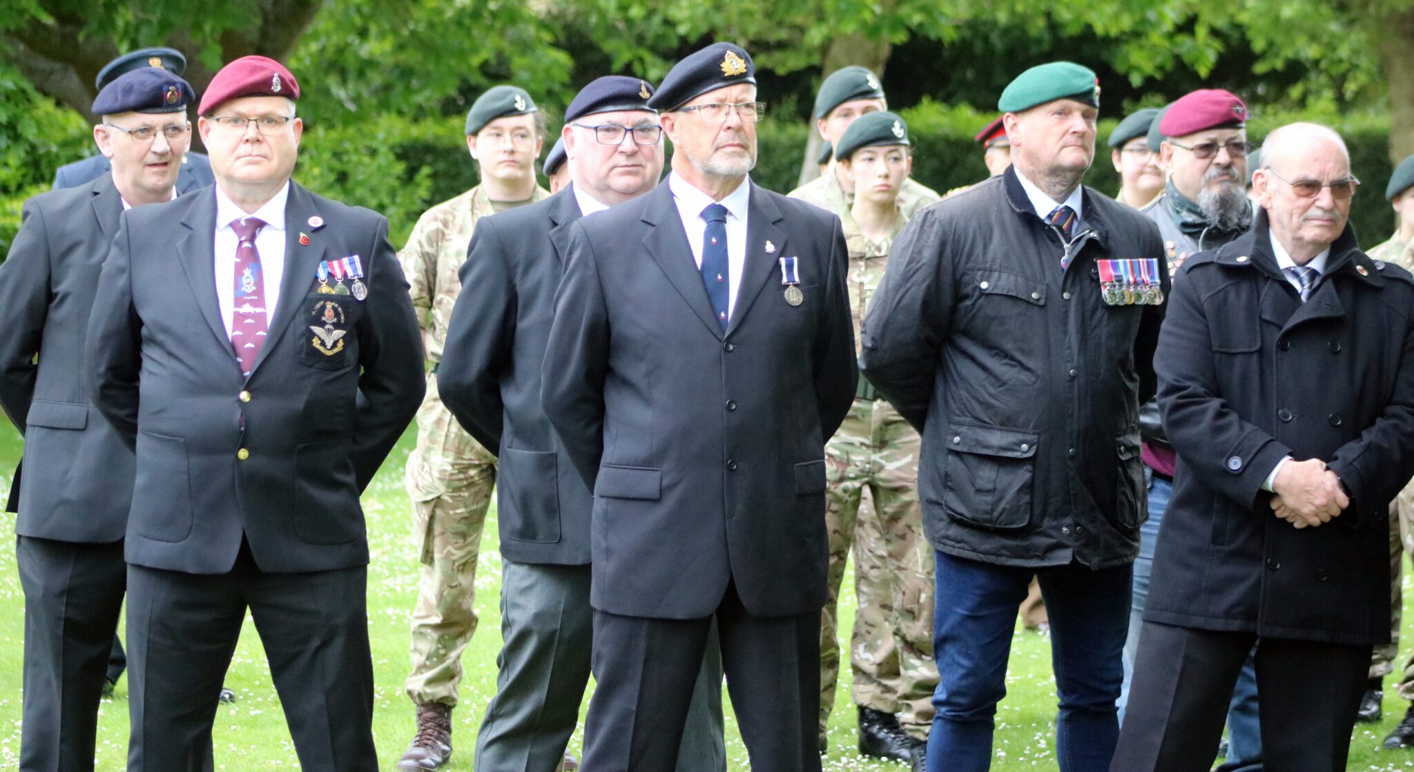 A group of veterans stand at ease.