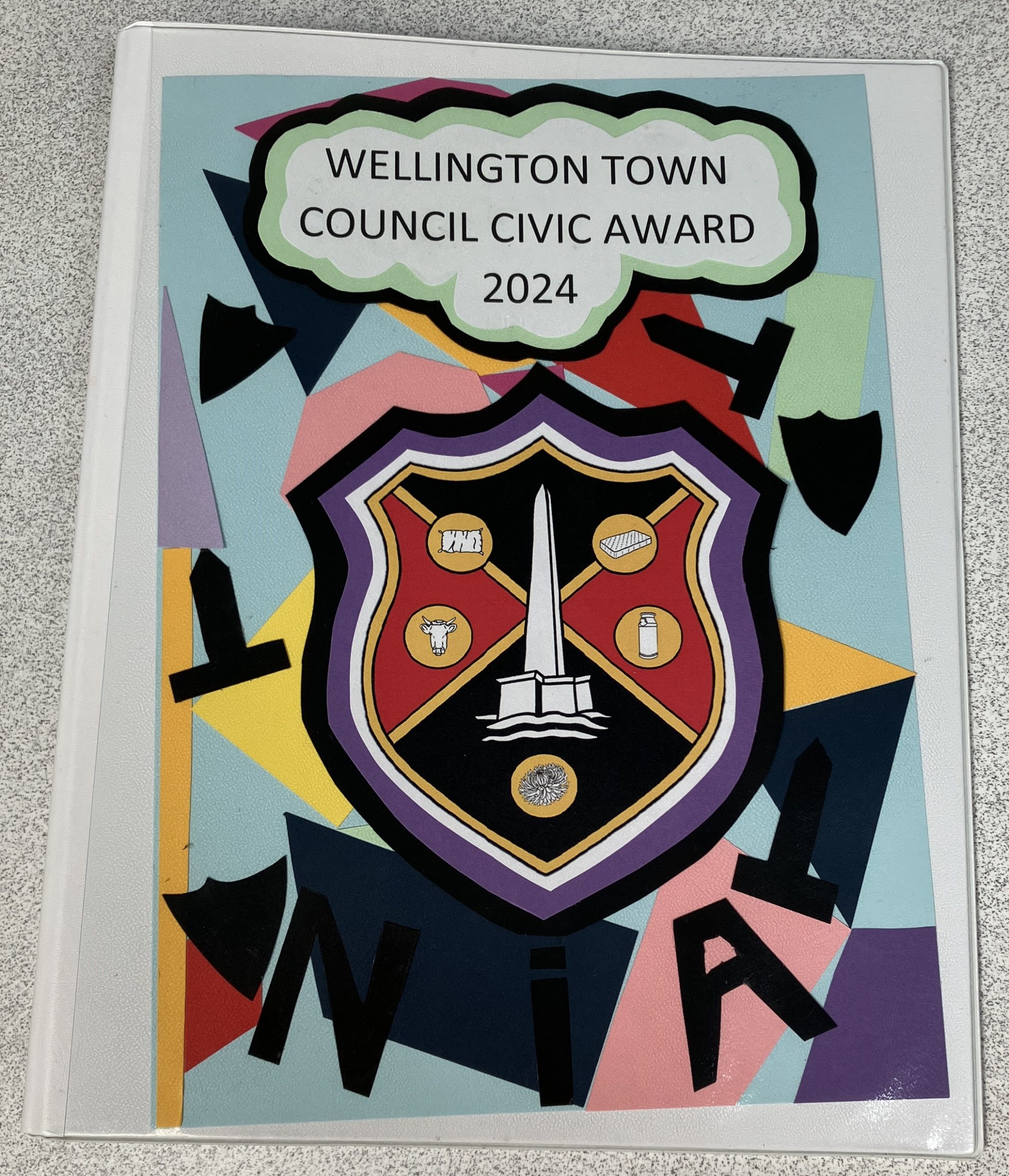 A decorated front of a ring binder. Reads "Wellington Town Council Civic Award 2024"