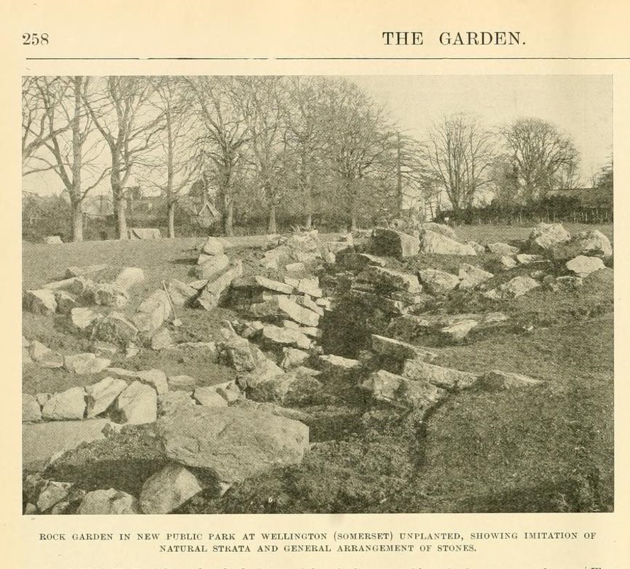 A newspaper image of a work-in-progress rock garden. The caption underneath the image reads: Rock garden in new public park at Wellington (Somerset) unplanted, showing imitation of natural strata and general arrangement of stones