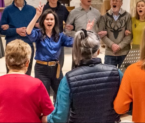 A person guiding singers.