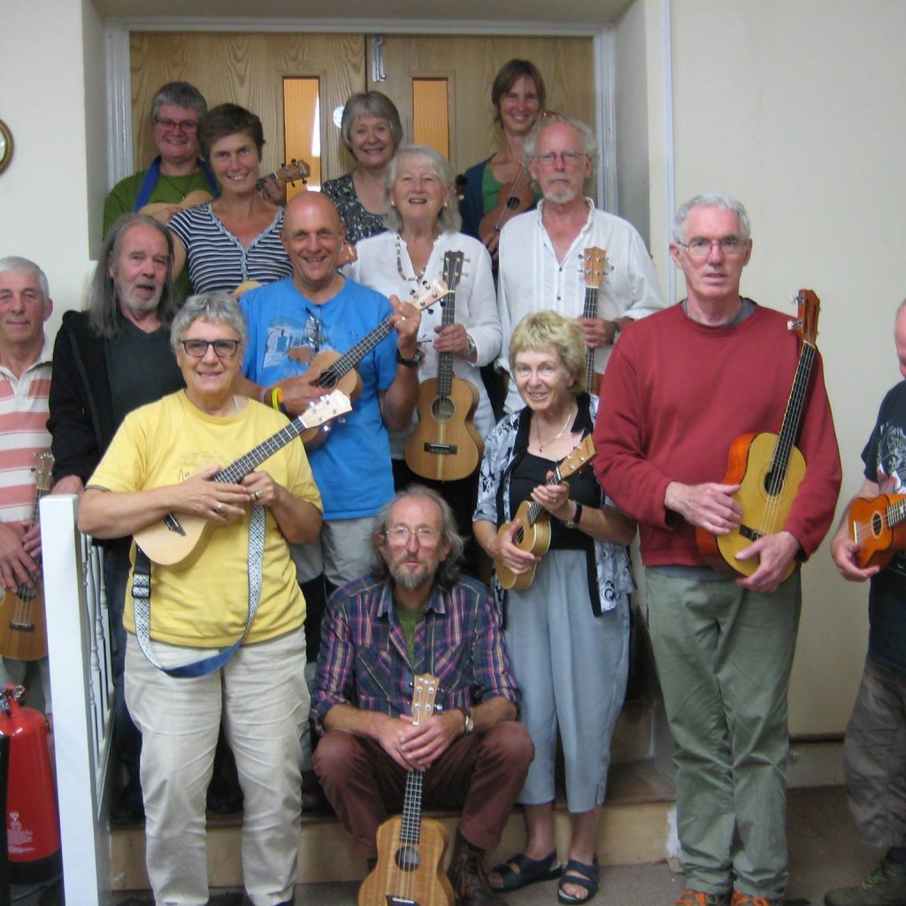 A group of people with ukuleles.
